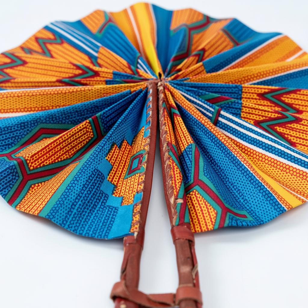 Close-up of bold orange and blue Ankara wax print fabric detail on folding fan