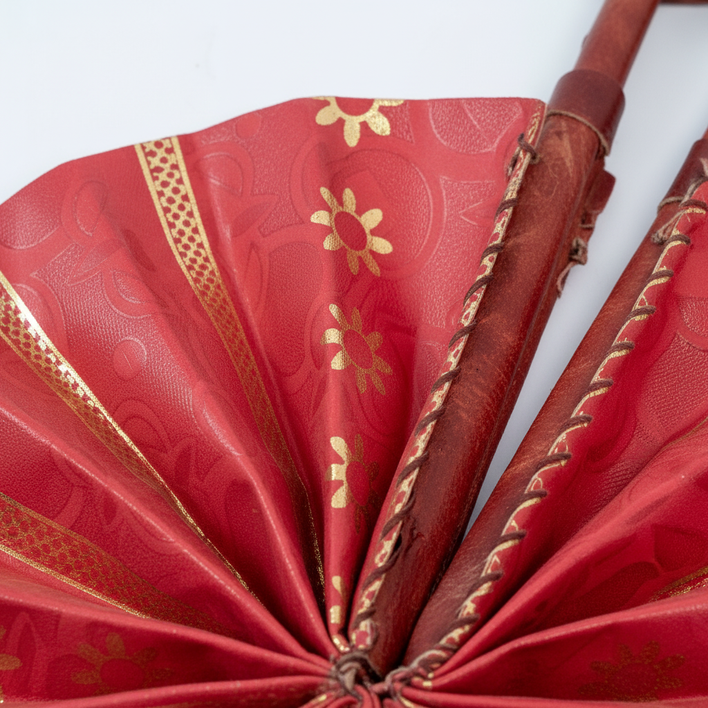 Close-up of red fabric with gold metallic stripe and sunburst floral motif detail