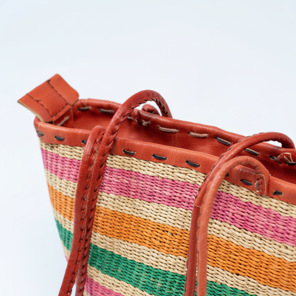 Close-up of red leather rim with hand-stitching and braided strap detail