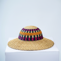 Handwoven Bolga sun hat with magenta and amber band, angled product view