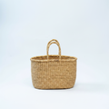 Handwoven natural straw basket tote, angled product view