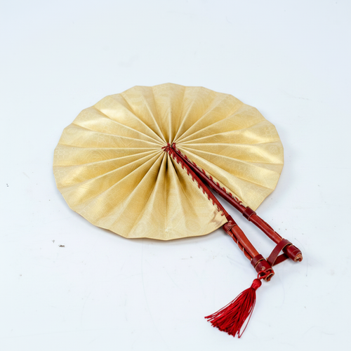 Handmade cream circular folding fan, angled view showing red leather sticks